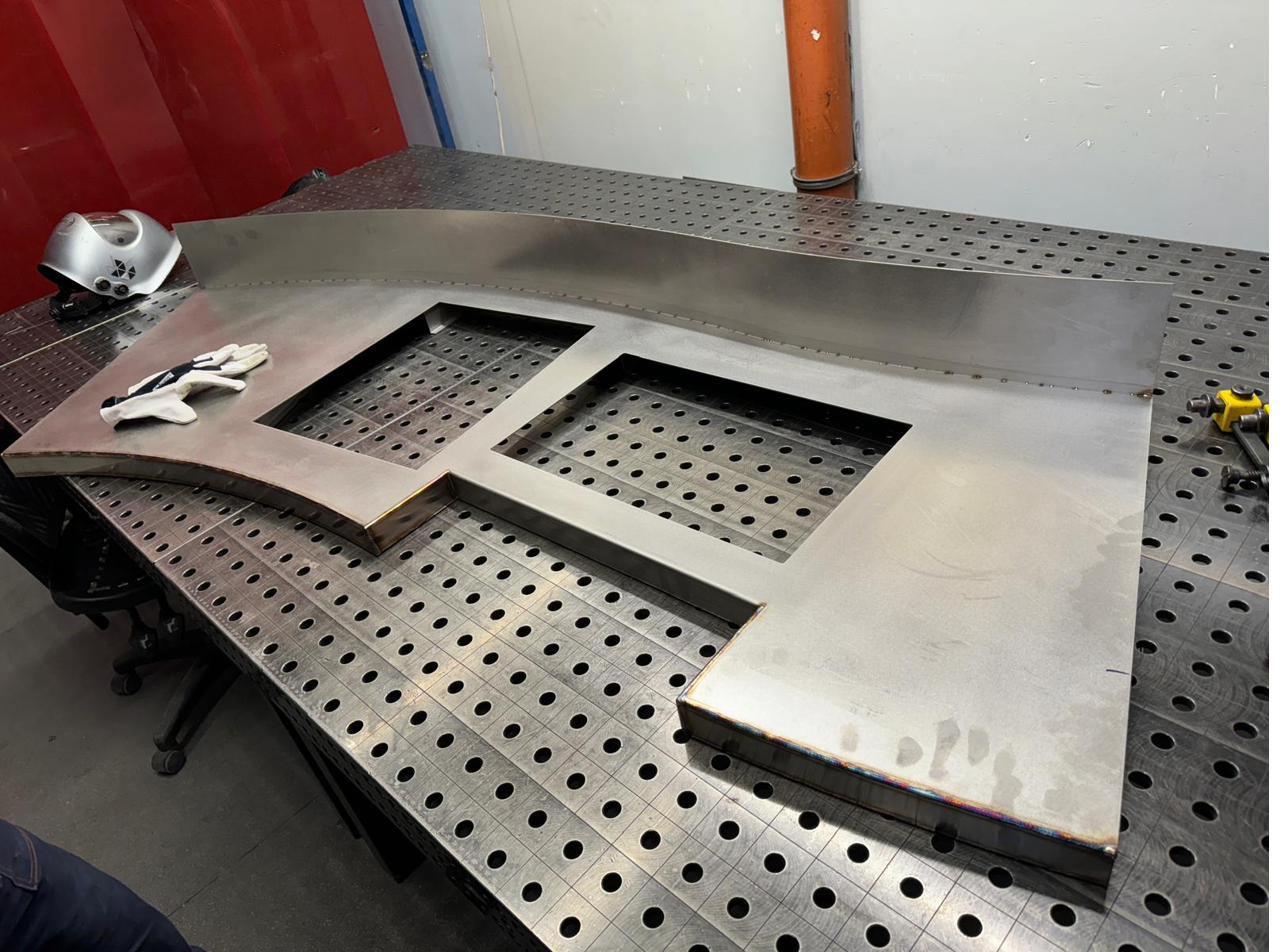Large welded stainless steel part on welding table
