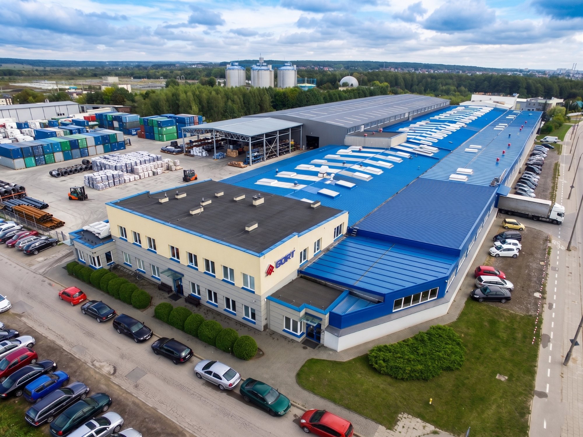 Aerial view of GORT production facility in Białystok — 12,000 m² hall with logistics yard, containers and adjacent transport infrastructure